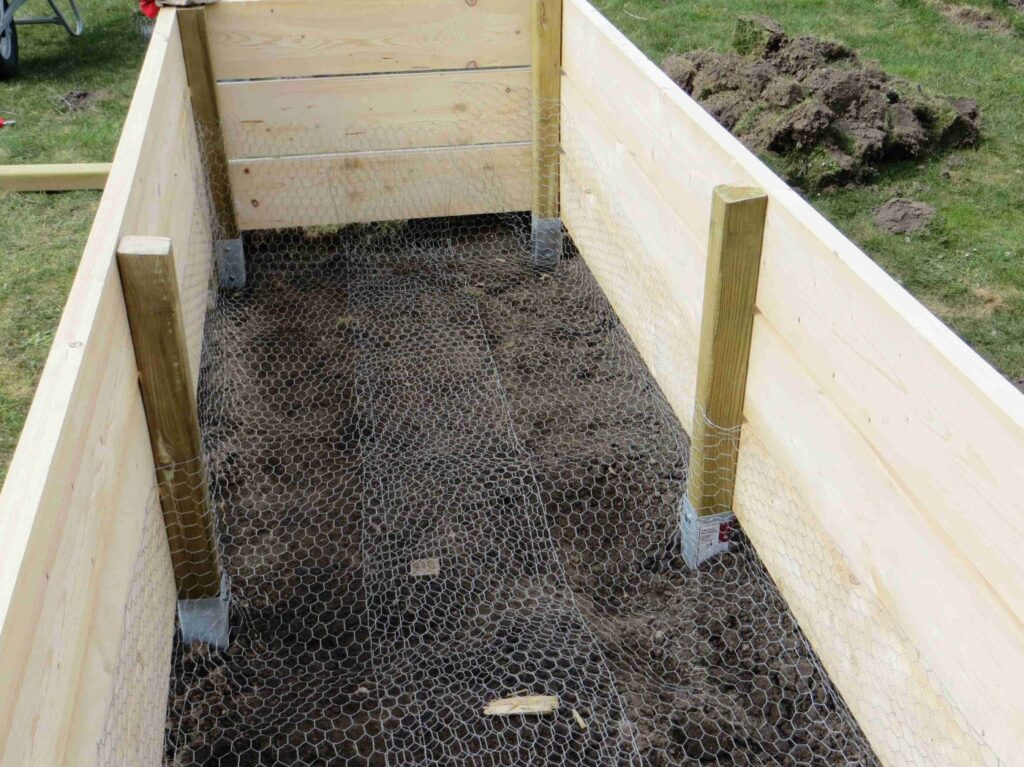 Das Gitter an den Holzwänden raufziehen und dort befestigen.