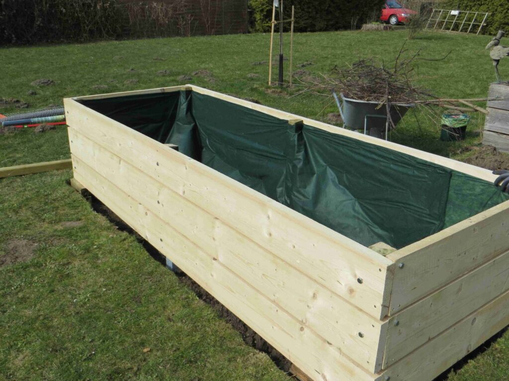 Damit das Holz geschützt wird und das Beet nicht so schnell austrocknet, kann es mit Folie ausgekleidet werden.