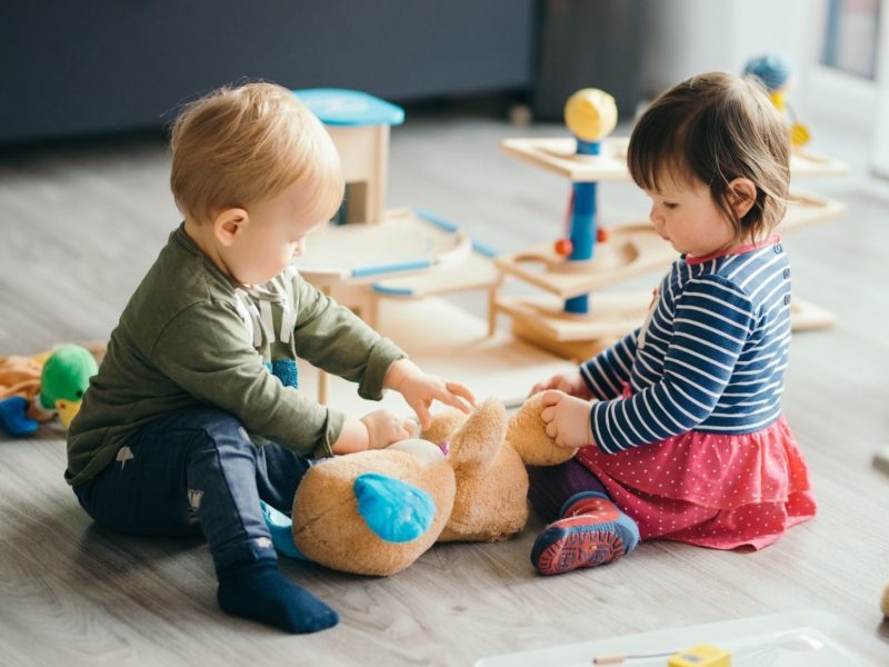 Kinder spielen am Boden