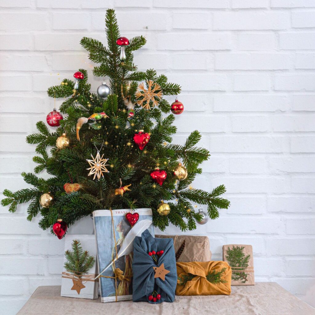 Christbaum aus Reisig in der Vase mit Geschenken
