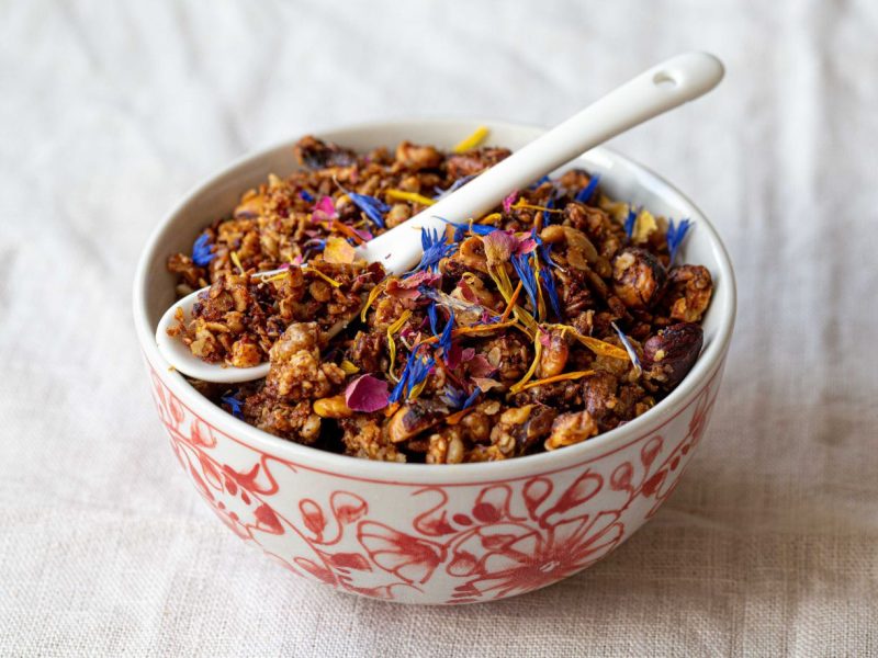 Schüssel mit Granola und essbaren Blüten