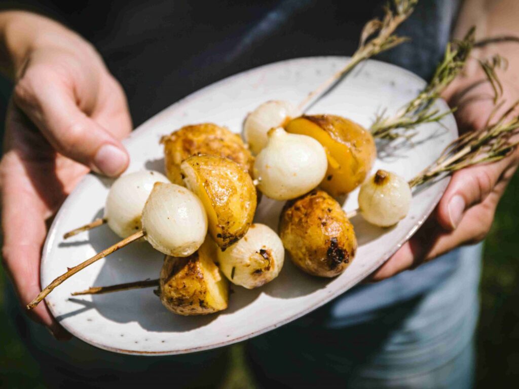Erdäpfel und Zwiebel auf 3 Rosmarinzweige aufgespießt